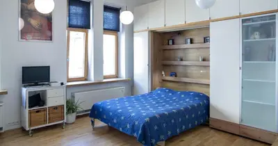 a bedroom with a bed and a tv in it at New Sweet One in Kraków