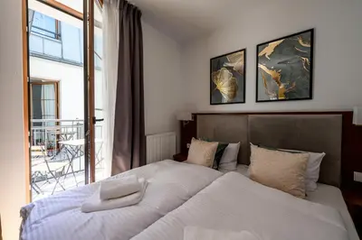 a bedroom with two beds and a balcony at ON/SET APARTHOTEL in Kraków