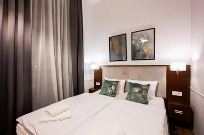 a bedroom with a white bed with two pillows at ON/SET APARTHOTEL in Kraków