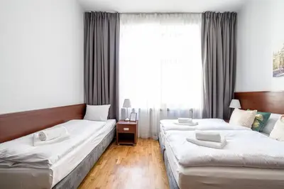 two beds in a hotel room with a window at ON/SET APARTHOTEL in Kraków