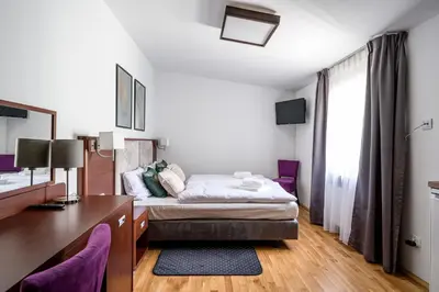 a bedroom with a bed and a desk and a window at ON/SET APARTHOTEL in Kraków