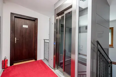 a hallway with a wooden door and a red carpet at ON/SET APARTHOTEL in Kraków