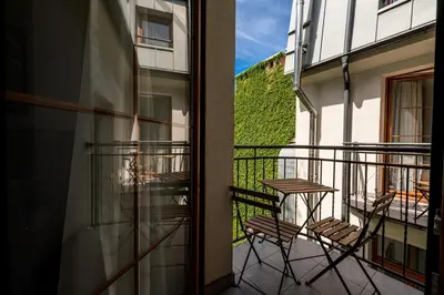 a balcony with two chairs and a table on it at ON/SET APARTHOTEL in Kraków