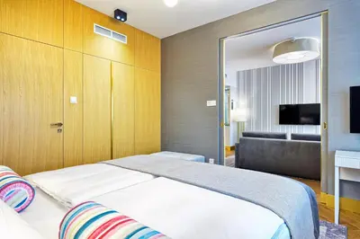 a bedroom with a bed and a couch and a television at Hotel Ferreus Modern Art Deco in Kraków