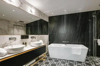 a bathroom with two sinks and a bath tub at Hotel Ferreus Modern Art Deco in Kraków