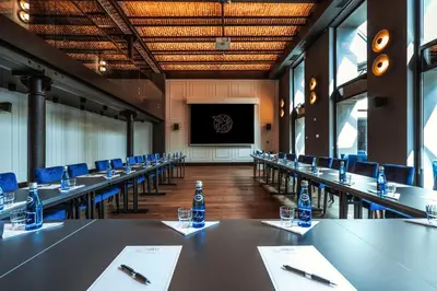 a conference room with tables and chairs and a screen at Hotel Ferreus Modern Art Deco in Kraków