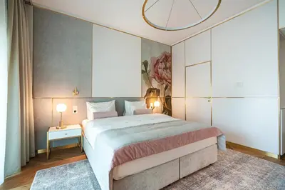 a bedroom with a large bed and a chandelier at Hotel Ferreus Modern Art Deco in Kraków