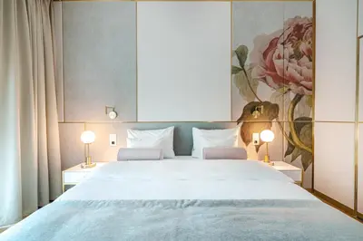a bedroom with a large bed with two lamps at Hotel Ferreus Modern Art Deco in Kraków