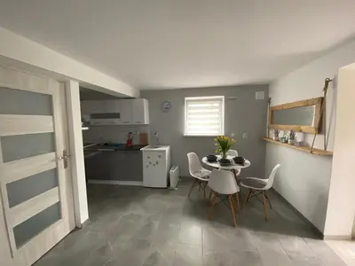 a kitchen and dining room with a table and chairs at Apartament Lotos in Zator