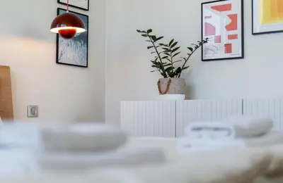 a table with a potted plant on a wall with pictures at Łobzowska 22 by Homeprime in Kraków