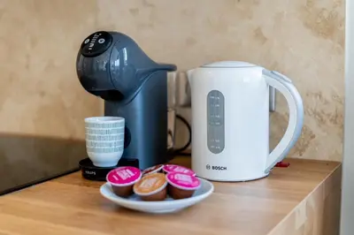 a counter with a coffee maker and a plate of cupcakes at Łobzowska 22 by Homeprime in Kraków