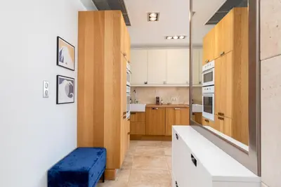 a kitchen with wooden cabinets and a blue bench at Łobzowska 22 by Homeprime in Kraków