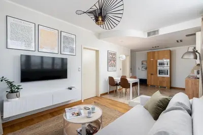 a living room with a white couch and a flat screen tv at Łobzowska 22 by Homeprime in Kraków