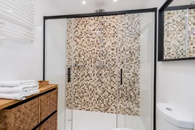 a bathroom with a shower with a glass door at Łobzowska 22 by Homeprime in Kraków