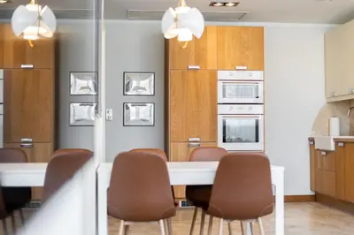 a kitchen with a white table and chairs and a kitchen withermott at Łobzowska 22 by Homeprime in Kraków