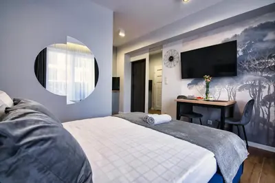 a bedroom with a bed and a desk and a tv at Apartament dla dwojga in Zator