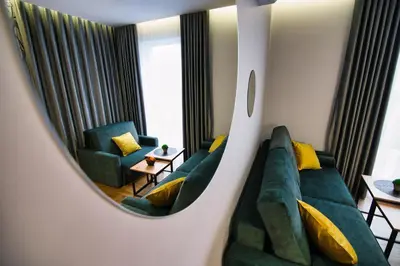 a living room with a couch and a mirror at Capital apartaments in Zator