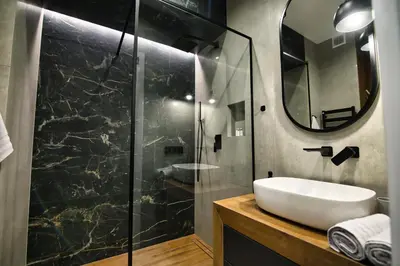 a bathroom with a sink and a shower with a mirror at Capital apartaments in Zator