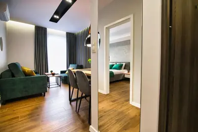 a living room and a bedroom with a bed and a mirror at Capital apartaments in Zator