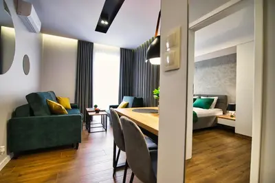 a dining room and living room with a table and chairs at Capital apartaments in Zator
