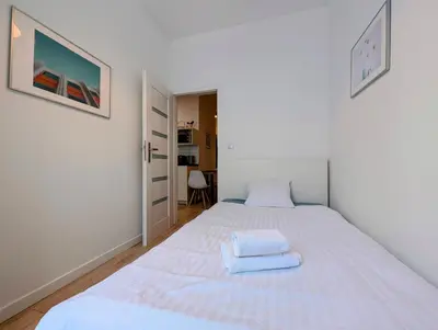 a bedroom with a white bed with two towels on it at Mazowiecka 11 by Homeprime in Kraków