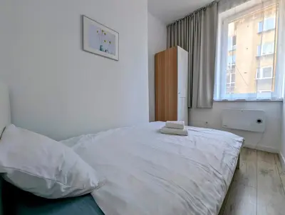 a bedroom with a large white bed with a window at Mazowiecka 11 by Homeprime in Kraków
