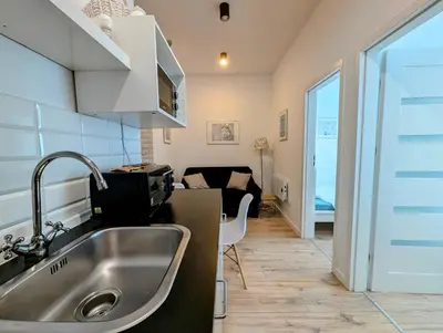 a kitchen with a sink and a living room at Mazowiecka 11 by Homeprime in Kraków