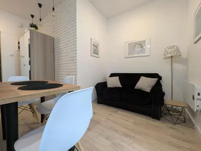 a living room with a black couch and a table at Mazowiecka 11 by Homeprime in Kraków