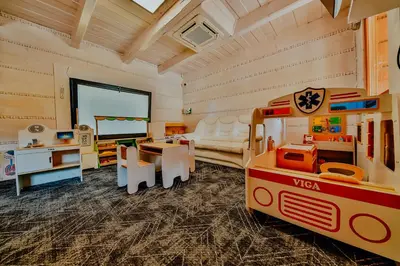 a play room with a toy bus and a table at Kompleks Gazdówka - Domki Rabka-Zdrój in Ponice