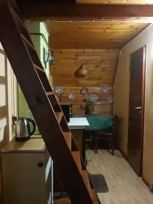 a kitchen with a staircase leading up to a room with a table at ELDORADO - całoroczny domek wakacyjny 35 km od Krakowa in Stróża