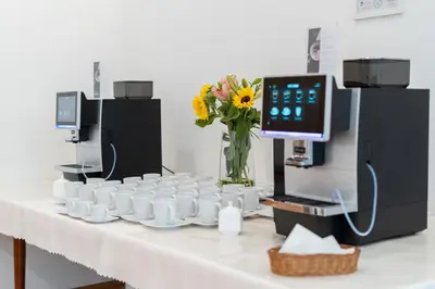 a table with cups and a vase with flowers on it at Hotel Artur in Kraków