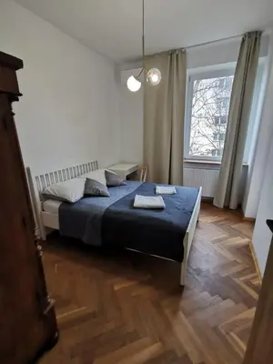 a bedroom with a blue bed and a window at Apartament z klimatyzacją in Kraków