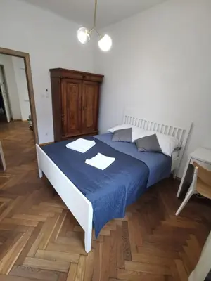 a bedroom with a bed with a blue blanket at Apartament z klimatyzacją in Kraków
