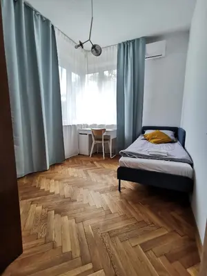 a bedroom with a bed and a wooden floor at Apartament z klimatyzacją in Kraków