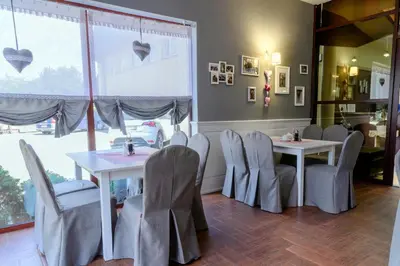 a restaurant with two tables and chairs and a window at Hotel Relax in Kęty