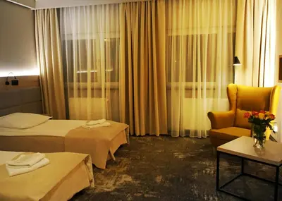 a hotel room with two beds and a chair at Hotel Relax in Kęty