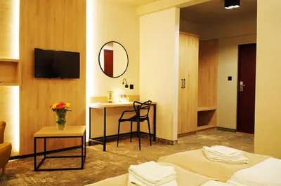 a hotel room with two beds and a table and a mirror at Hotel Relax in Kęty