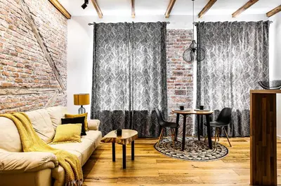 a living room with a couch and a brick wall at Charming Studio with Air Conditioning, Old Town & Kazimierz in Kraków