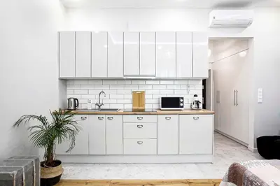 a kitchen with white cabinets and a sink at Charming Studio with Air Conditioning, Old Town & Kazimierz in Kraków