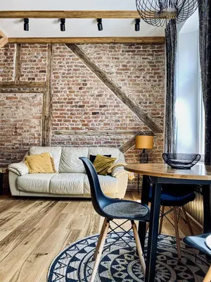 a living room with a brick wall and a table and chairs at Charming Studio with Air Conditioning, Old Town & Kazimierz in Kraków