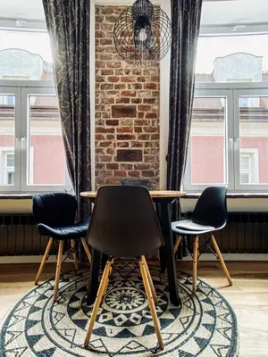 a table and four chairs in a room with windows at Charming Studio with Air Conditioning, Old Town & Kazimierz in Kraków