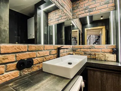 a bathroom with a white sink and a brick wall at Charming Studio with Air Conditioning, Old Town & Kazimierz in Kraków