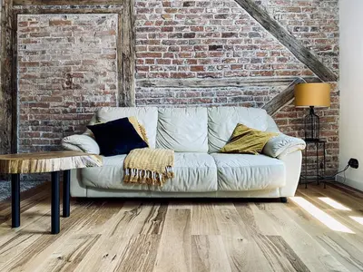 a white couch in a room with a brick wall at Charming Studio with Air Conditioning, Old Town & Kazimierz in Kraków