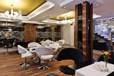 a restaurant with white and black chairs and tables at Jasmin Complex Resort & Spa in Krzeszów Dolny