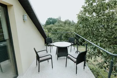 a balcony with chairs and a table on a balcony at Skava Apartments Zator Energylandia in Wadowice