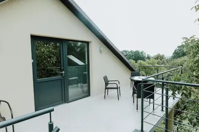 a balcony with a door and chairs on it at Skava Apartments Zator Energylandia in Wadowice