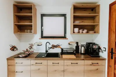 a kitchen with wooden cabinets and a sink at Skava Apartments Zator Energylandia in Wadowice