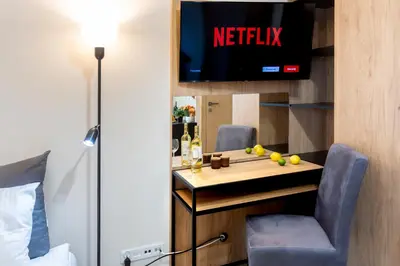 a hotel room with a bar with a tv on a wall at Aparts Near Main Station in Kraków