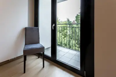 a chair in front of a door with a balcony at Aparts Near Main Station in Kraków