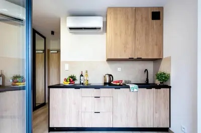 a kitchen with wooden cabinets and a sink at Aparts Near Main Station in Kraków